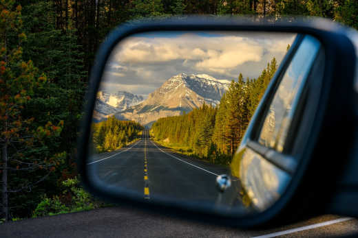 La vue dans le rétroviseur montre l'impressionnant paysage montagneux du parc national de Jasper, dans l'Alberta, au Canada.