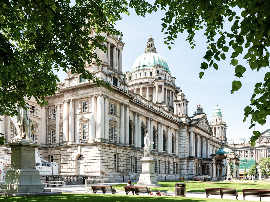 Majestätisches Rathaus mit grünlicher Kuppel, umgeben von gepflegten Gärten. Belfast, County Antrim, Nordirland.