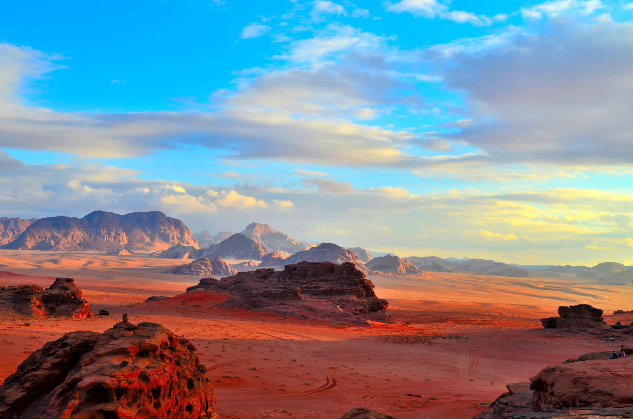 Der weitläufige Wüstenlandschaft Wadi Rum in Jordanien in feurigem Rot des Sonnenuntergangs.