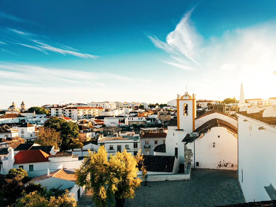 Blick auf eine Altstadt mit weißen Gebäuden unter blauem Himmel. Tavira, Algarve,  Portugal.
