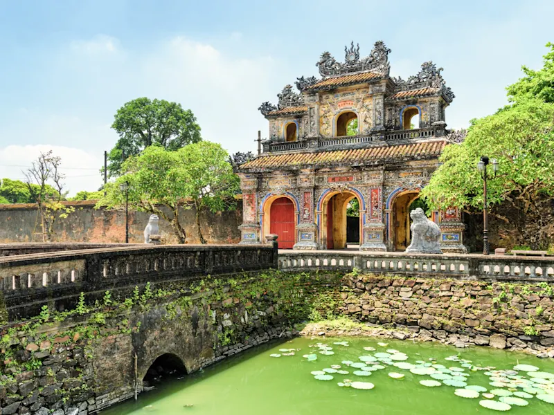 Hue, Vietnam Verzierte Eingangspforte der Kaiserstadt Hue mit Teich und steinernen Wächtern. Hue, Vietnam.
