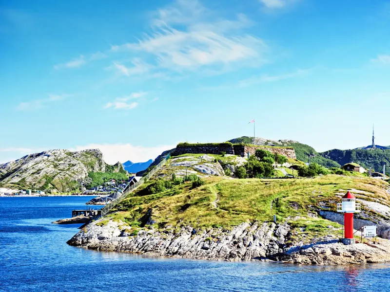 Historische Küstenfestung mit rotem Leuchtturm auf Felsen. Bodø, Nordland, Norwegen.