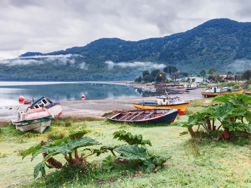 Chile, Los Lagos, Chaitén Kleine Fischerboote an einer ruhigen Bucht mit grünen Hügeln. Chaitén, Los Lagos, Chile.