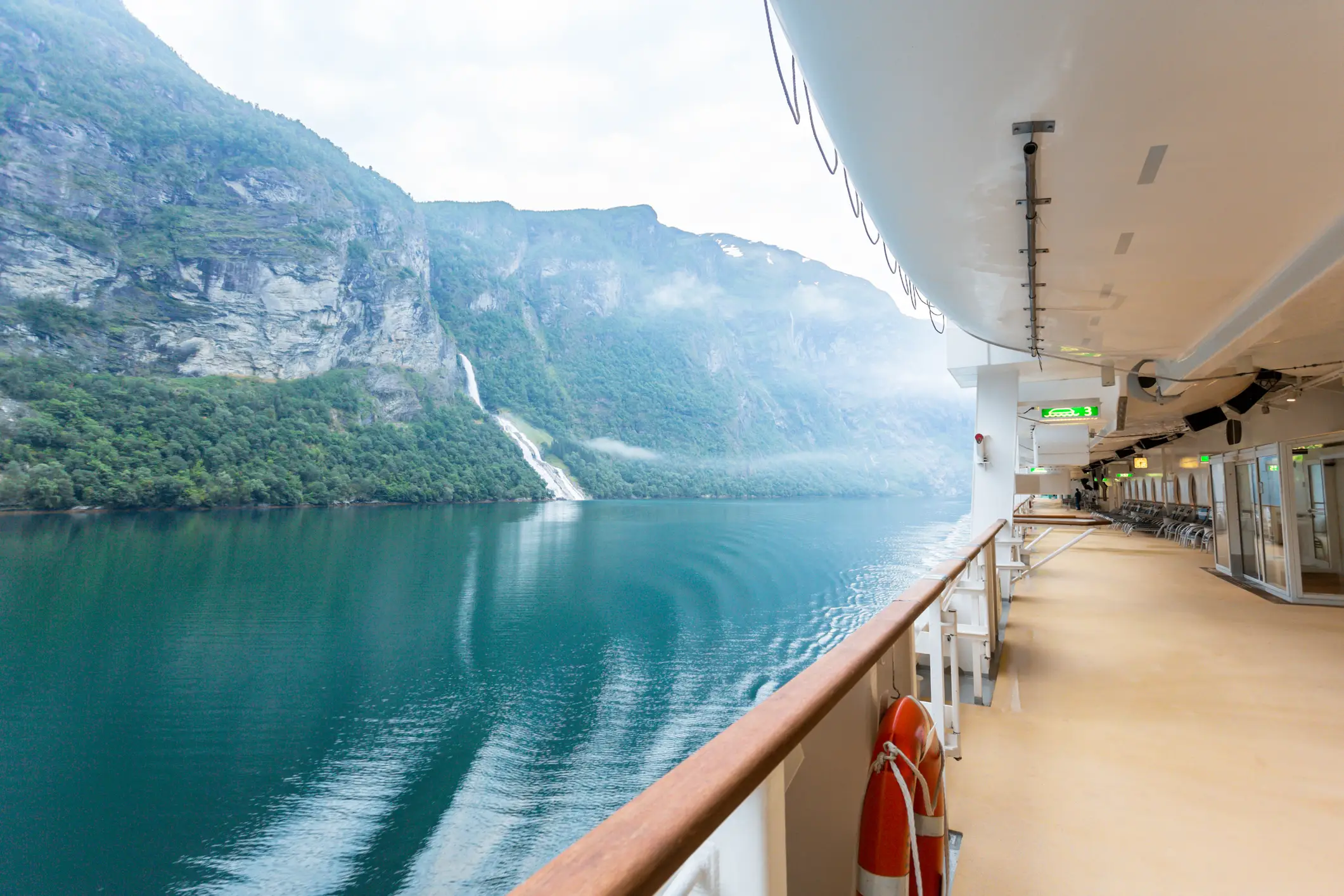 Blick von dem Deck eines Kreuzfahrtschiffes auf Berge in einem Fjord