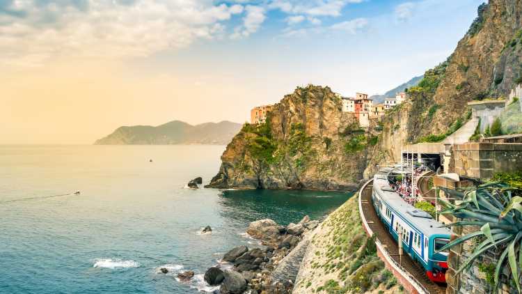 Bahnhof in einem kleinen Dorf mit bunten Häusern auf einer Klippe mit Blick aufs Meer. Der Nationalpark Cinque Terre mit seiner zerklüfteten Küste ist ein berühmtes Touristenziel in Ligurien, Italien