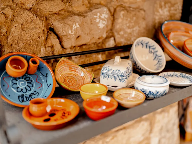 Handgefertigte bunte Keramikschalen auf einem rustikalen Regal. Palma, Balearen, Spanien.