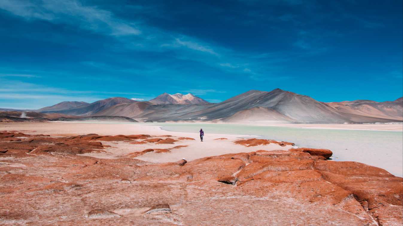 Magnifique panorama sur le désert d'Atacama au couleur rose pâle féérique. Un lieu de rêve à découvrir pendant votre voyage au Chili.