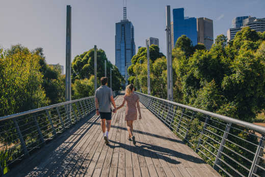 Couple se tenant par la main avec Melbourne en toile de fond