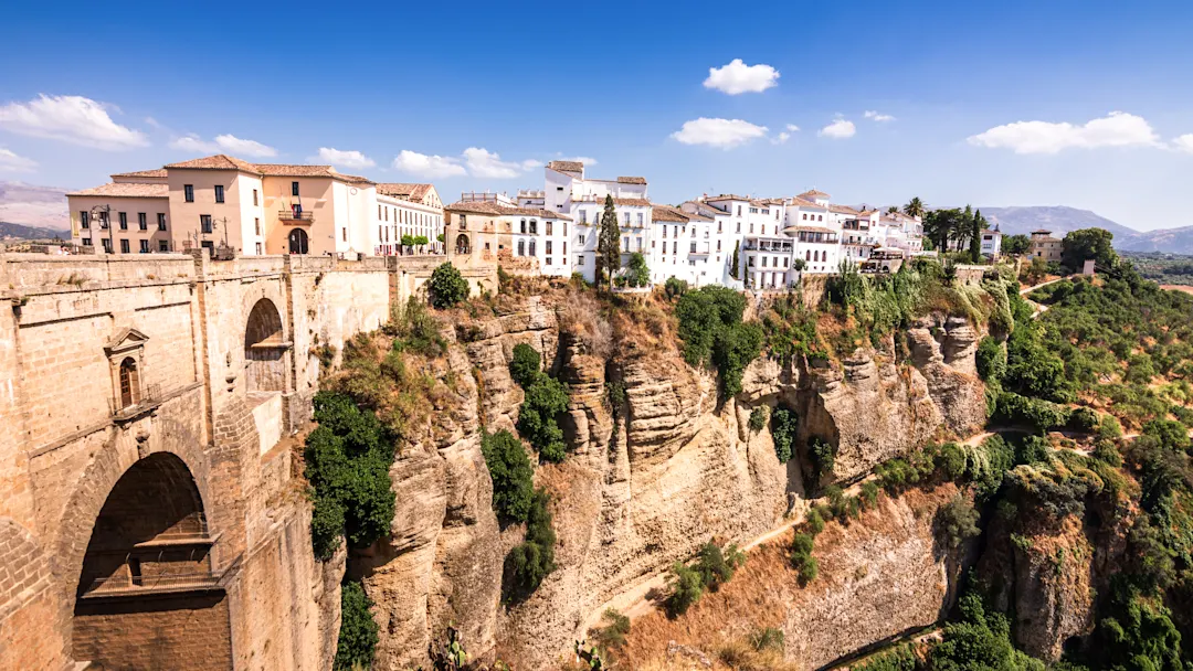 Stadt auf einer Felsklippe mit Blick auf eine tiefe Schlucht, umgeben von Natur. Ronda, Andalusien, Spanien.