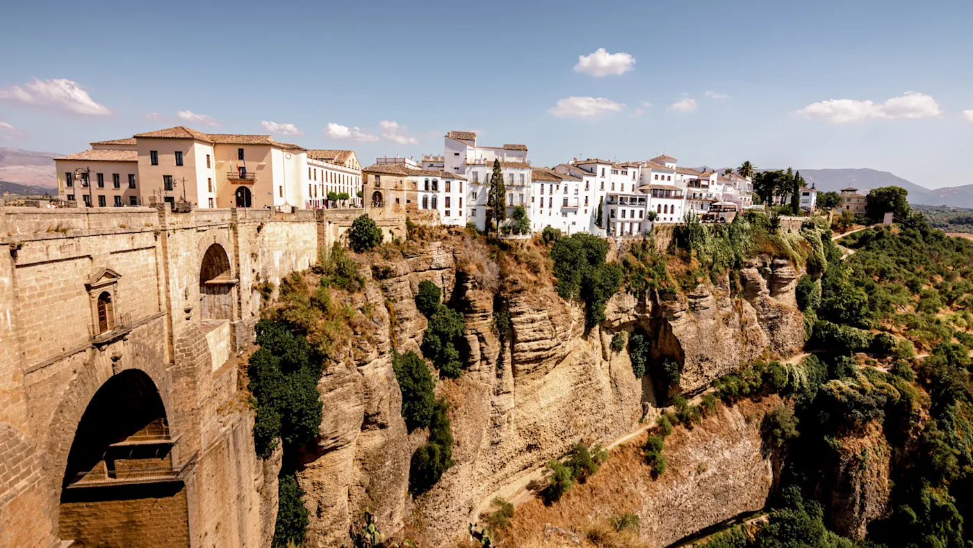Stadt auf einer Felsklippe mit Blick auf eine tiefe Schlucht, umgeben von Natur. Ronda, Andalusien, Spanien.