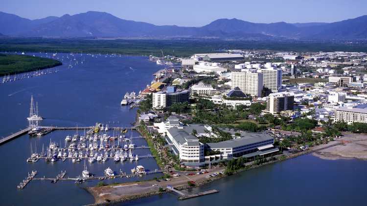 Oceania, Australia, Cairns seen from above surrounded by water and mountains in the background.