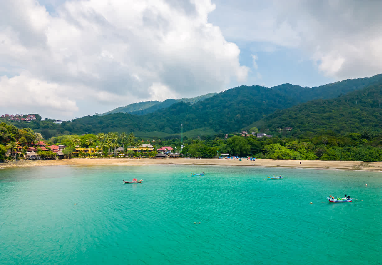 Drohnenaufnahme der Bambusbucht und des Strandes auf der Insel Koh Lanta, Thailand. Tropischer Wald in der Nähe des felsigen Strandes und weißer Sand mit türkisfarbenem Wasser.