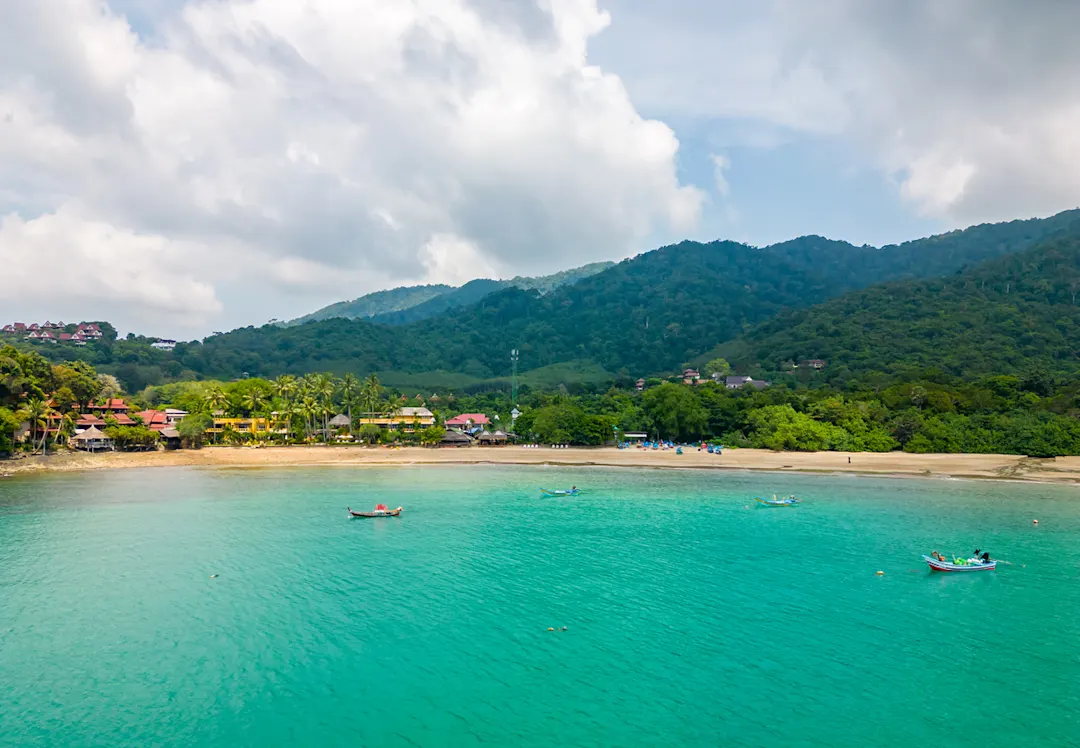 Thailand, Koh Lanta, Bamboo Beach Drohnenaufnahme der Bambusbucht und des Strandes auf der Insel Koh Lanta, Thailand. Tropischer Wald in der Nähe des felsigen Strandes und weißer Sand mit türkisfarbenem Wasser.