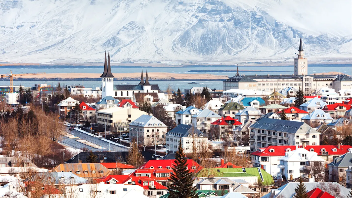 Reykjavik, Island Winteransicht von Reykjavik mit bunten Häuserdächern und schneebedeckten Bergen, Reykjavik, Island.