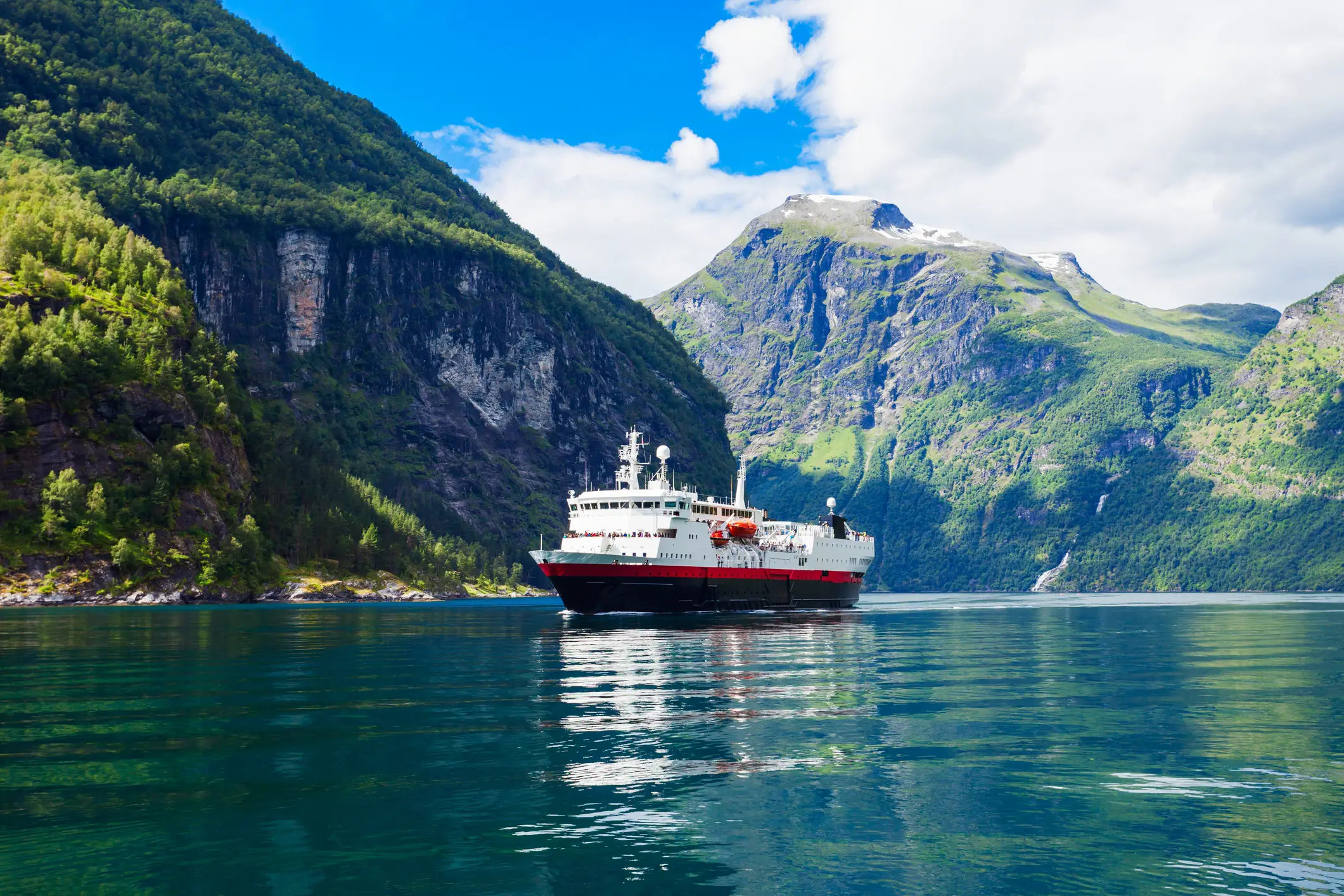 Postschiff vor einer sommerlichen Berglandschaft in einem Fjord