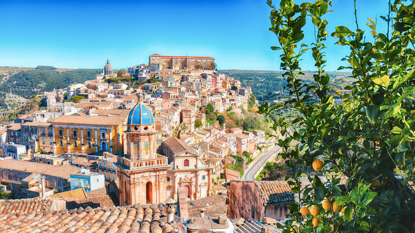 Italien, Sizilien, Ragusa Blick auf den historischen barocken Stadtkern Ragusas mit Zitronenbaum im Vordergrund