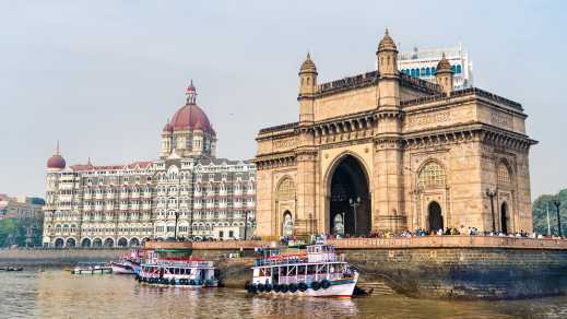 Vue depuis l'eau sur la Porte de l'Inde avec des bateaux en premier plan, à Mumbai, en Inde