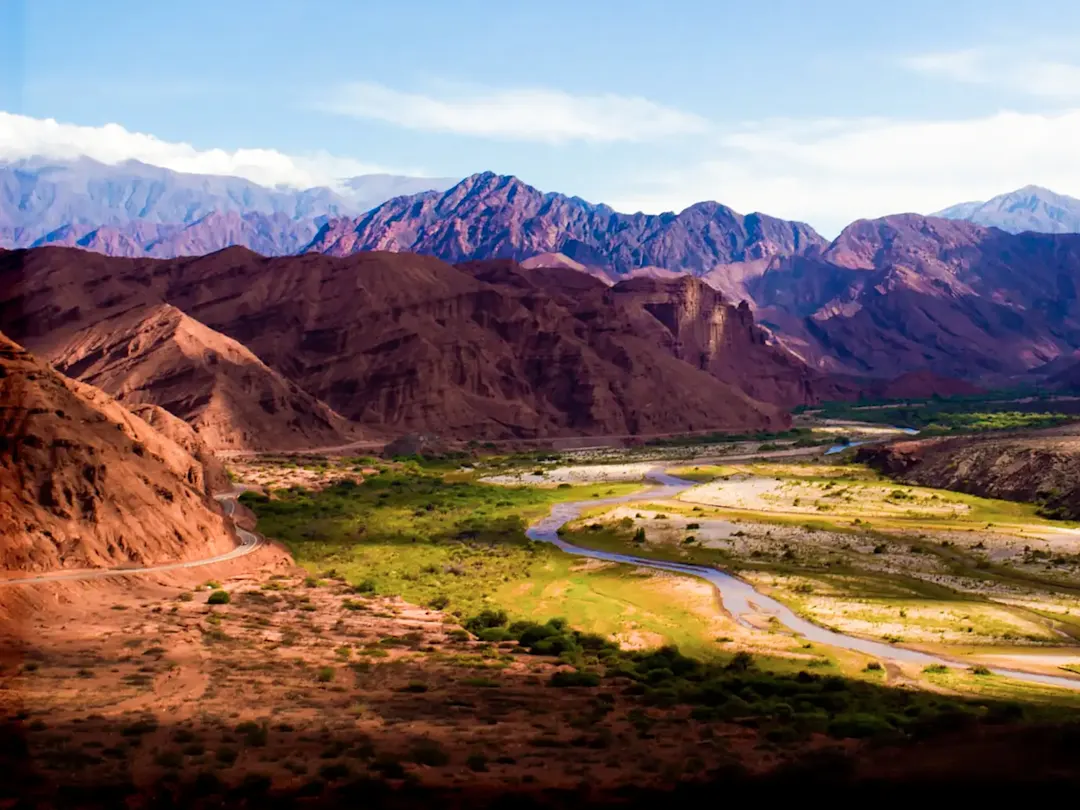 Rote Berge, Fluss und blauer Himmel in trockener Landschaft. Cafayate, Salta, Argentinien.

