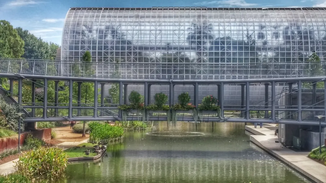 USA, Oklahoma City, Myriad Gardens Pont au-dessus d'un étang devant une serre, aux Myriad Botanical Gardens, aux Etats-Unis