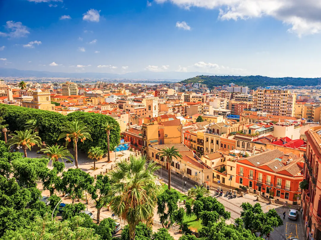 Panoramablick auf die Stadt mit Palmen und bunten Gebäuden. Cagliari, Sardinien, Italien.