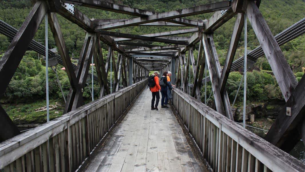 Touristes avec un sac à dos sur un pont menant à la montagne à Greymouth, Nouvelle-Zélande