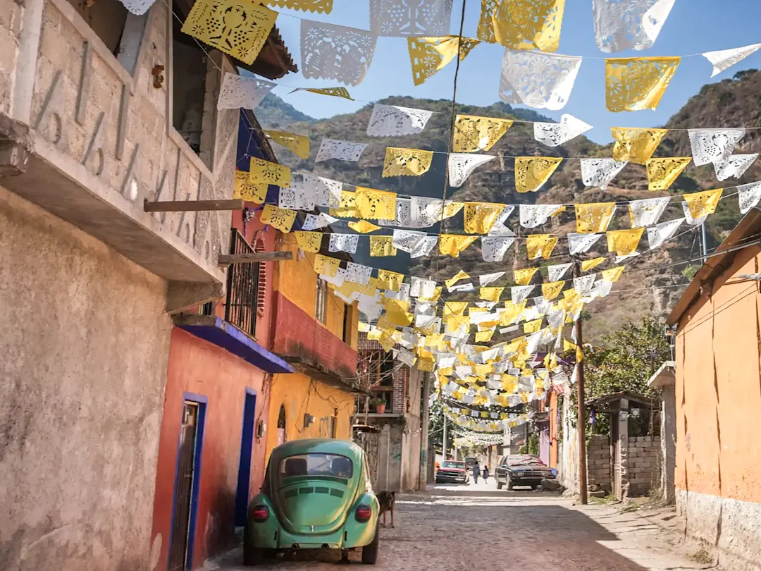 Bunte Gasse mit Fahnen und VW-Käfer. Malinalco, México, Mexiko.
