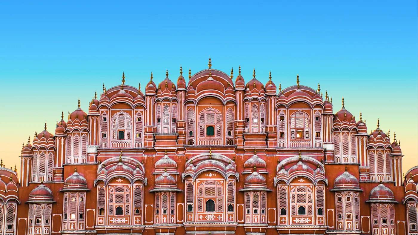 Jaipur, Rajasthan, Indien Fassade des Hawa Mahal mit kunstvollen Fenstern und Kuppeln bei Sonnenaufgang. Jaipur, Rajasthan, Indien.