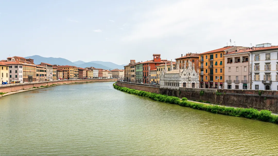 Blick auf den Arno-Fluss und die bunte Architektur in Pisa, Toskana, Italien.
