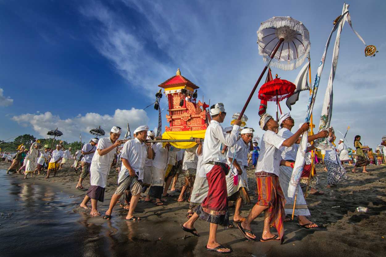 Personnes en habits traditionnels sur la plage, à Lombok, en Indonésie