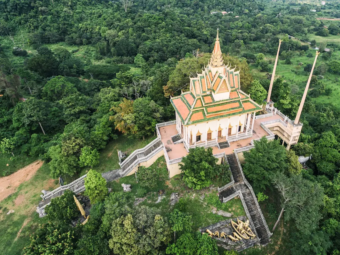 Buddhistische Tempelanlage inmitten von grüner Landschaft. Wat Ek Phnom, Battambang, Kambodscha.