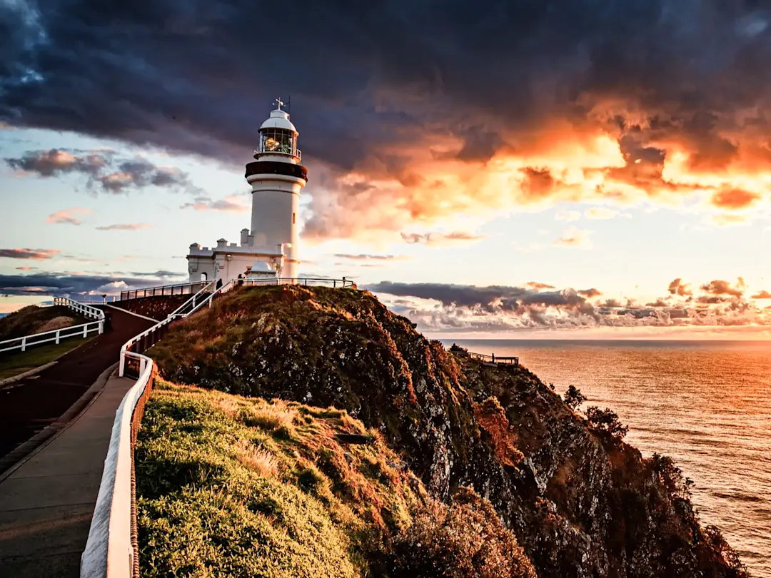 Leuchtturm auf Klippe bei Sonnenuntergang. Byron Bay, New South Wales, Australien.
