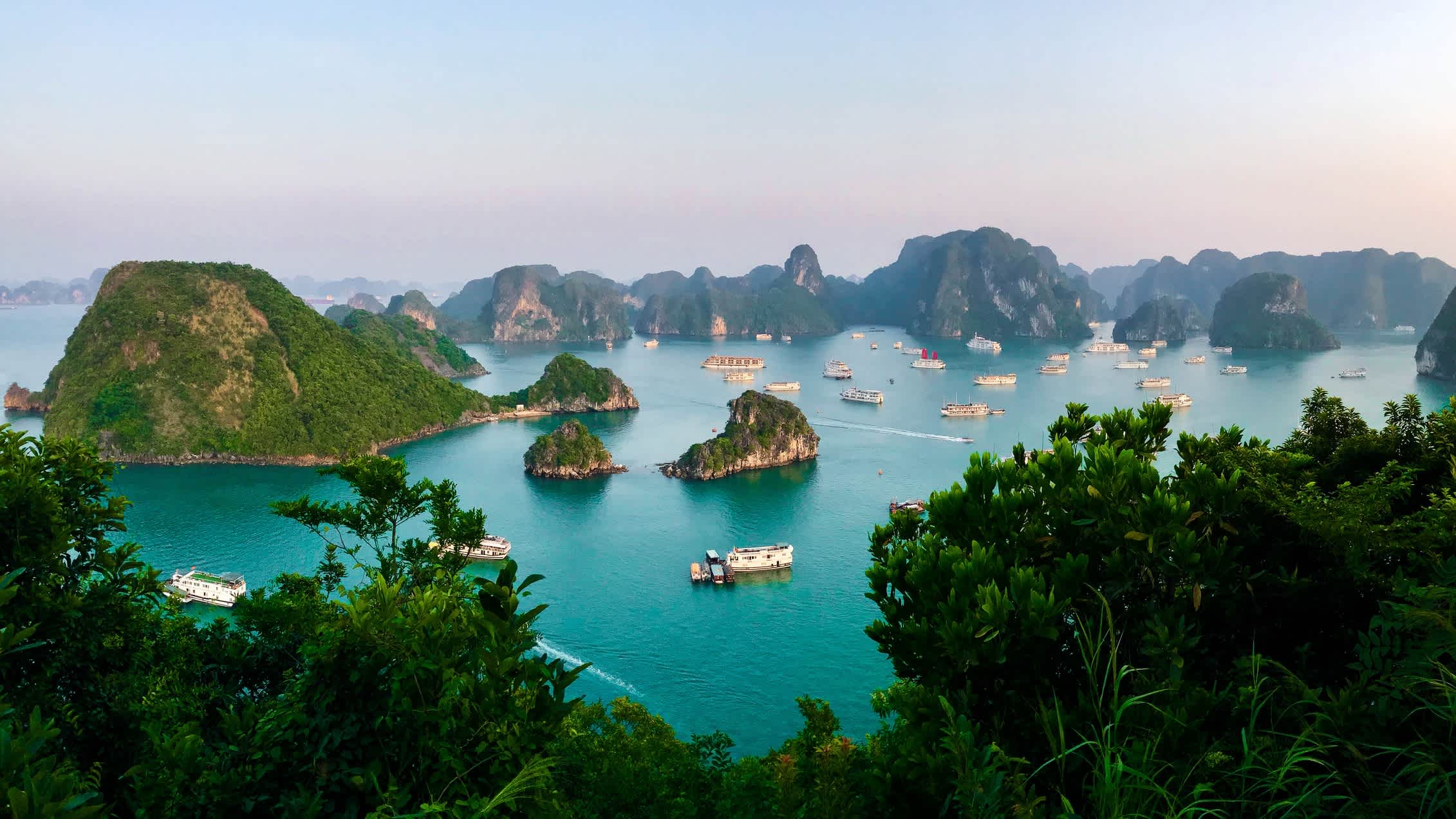 Panorama de la baie d'Halong avec des bateaux au coucher du soleil, Vietnam