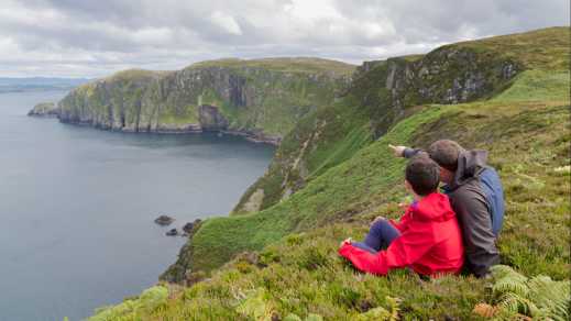 Vater und Sohn bewundern die Landschaft von Horn Head, Donegal, Irland.

