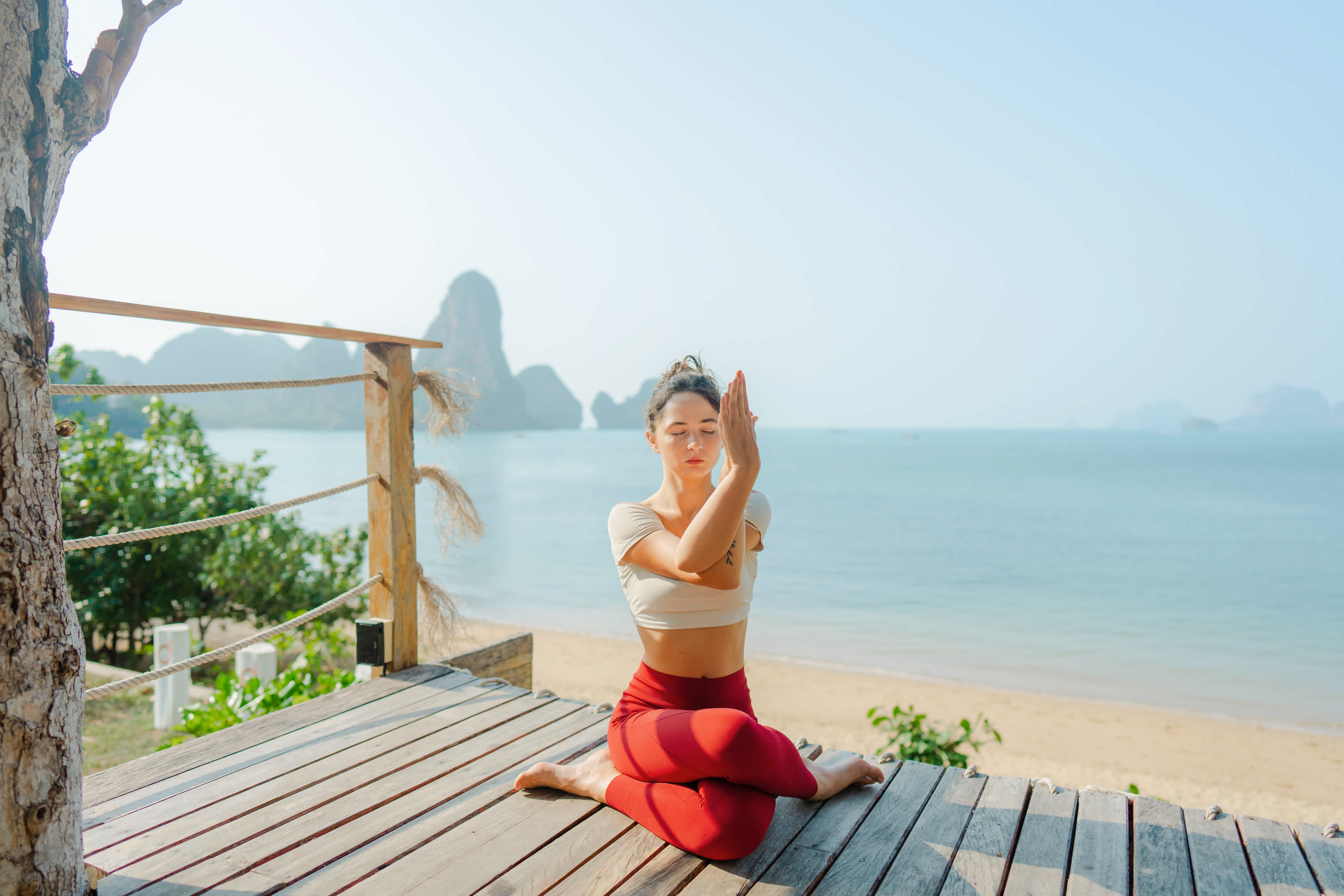 Frau beim Yoga am Strand in Krabi