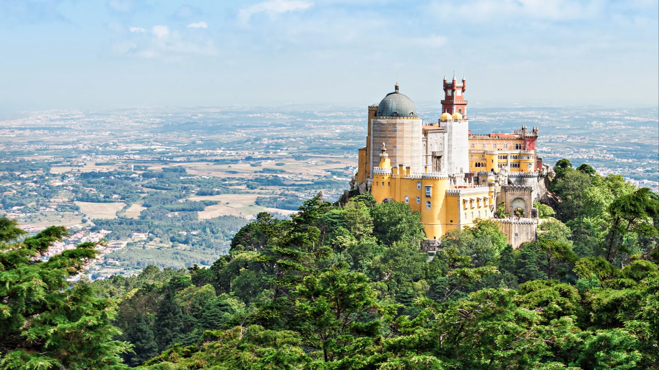 Panoramic view of the colorful Palácio da Pena on a wooded hill. Sintra, Lisbon, Portugal.