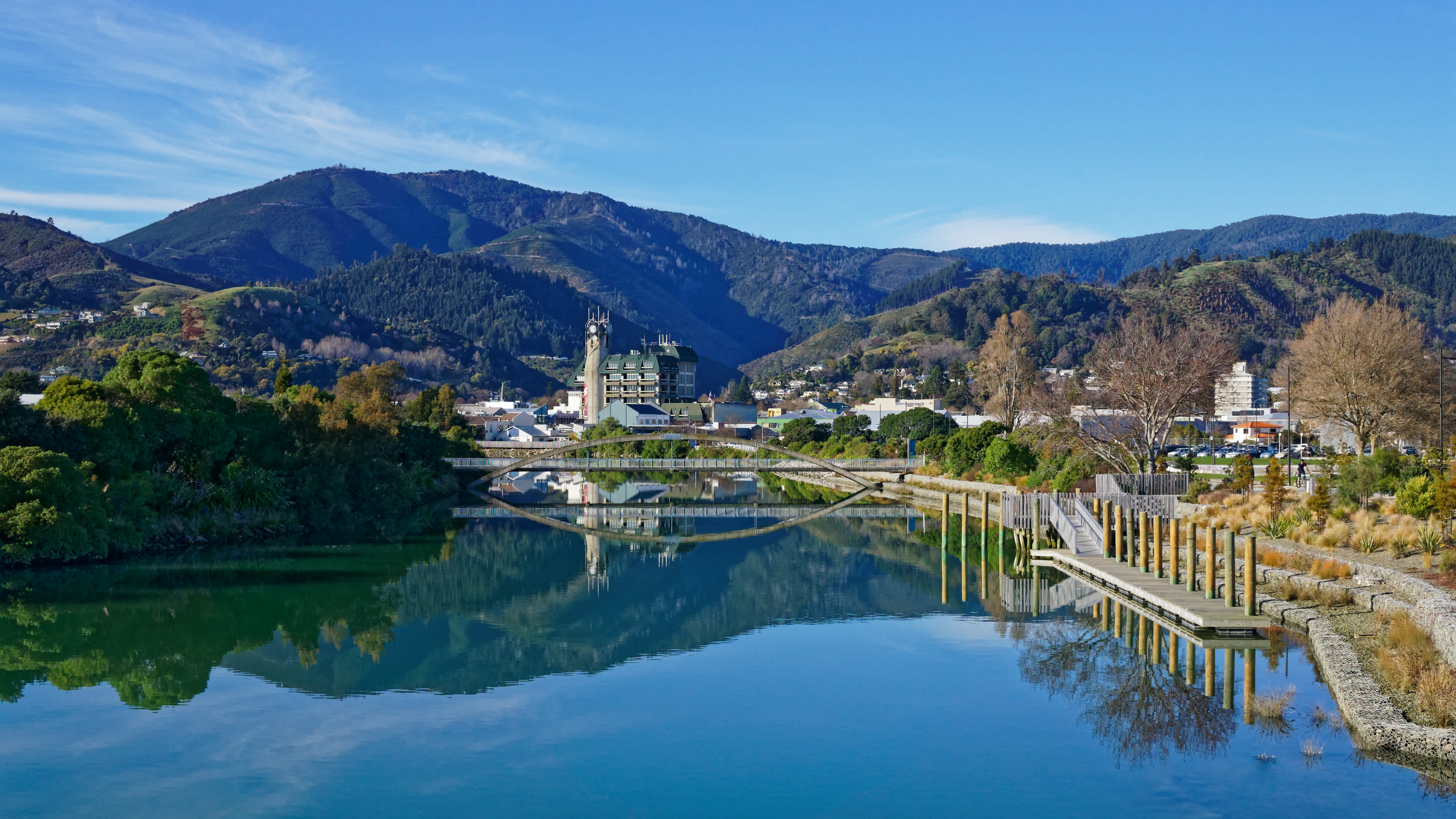 Panorama de la ville de Nelson se reflétant dans les eaux calmes de la rivière Maitai, en Nouvelle-Zélande.