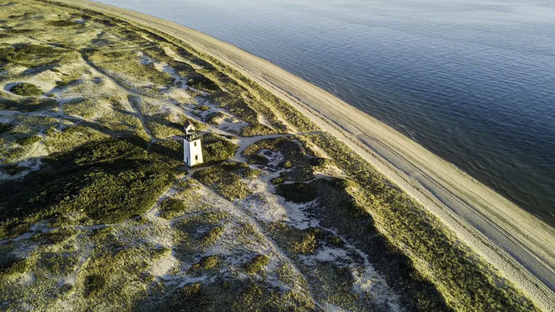 Luftaufnahme eines Leuchtturms an einer sandigen Küste mit Dünen. Cape Cod, Massachusetts, USA.