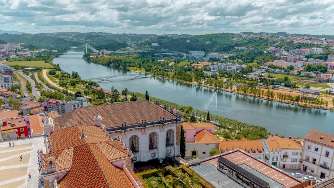 Fluss Mondego bei Coimbra beim Sonnernuntergang mit Uferpromenade

