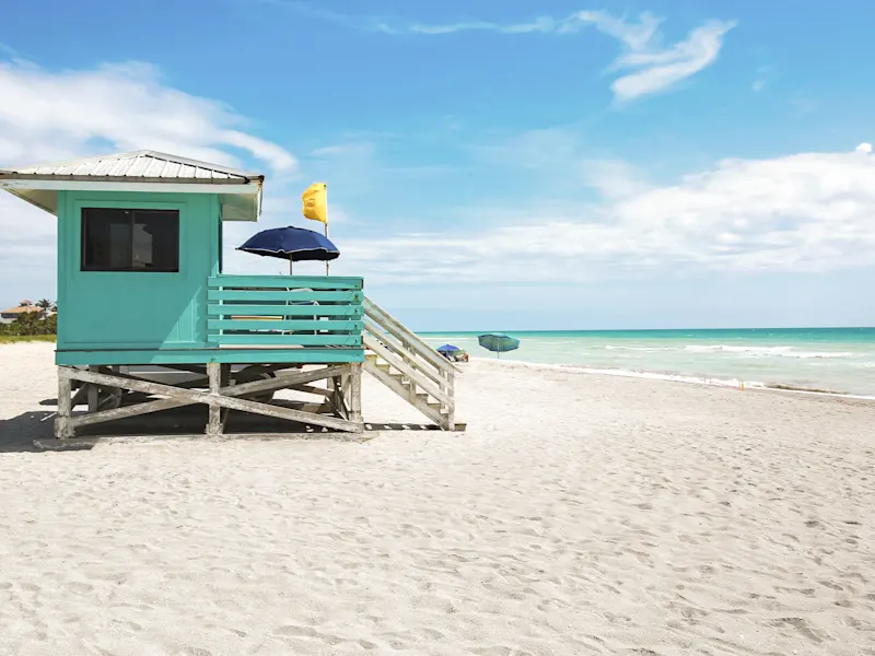 Strandhütte mit Sonnenschirmen an einem ruhigen Sandstrand. Tampa, Florida, USA.