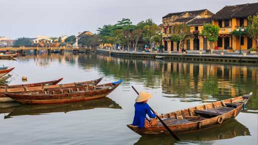 Femme à bord d'une embarcation traditionnelle sur le fleuve à Hoi An, au Vietnam