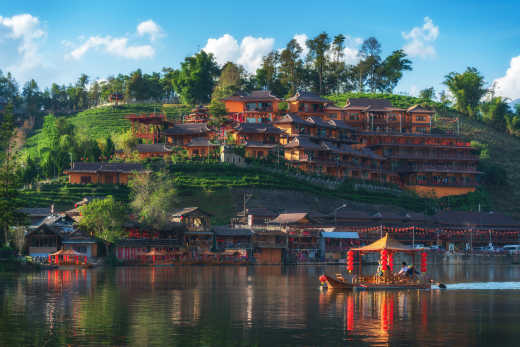 Villag de Ban Rak Thai sur une colline verdoyante vu depuis la rivière