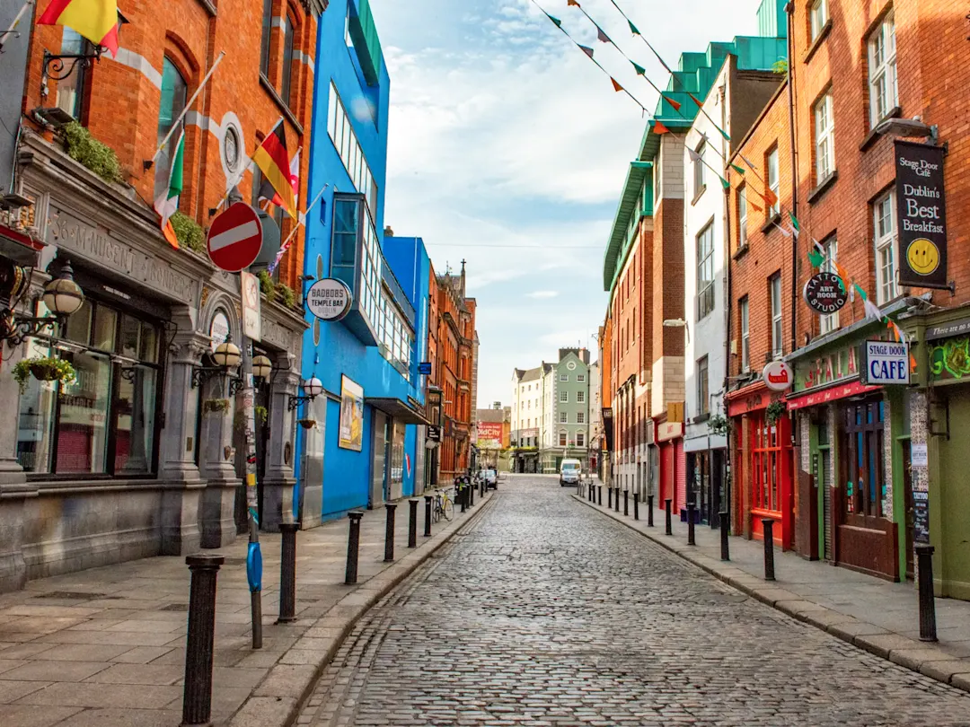 Kopfsteinpflasterstraße im lebendigen Viertel Temple Bar mit bunten Fassaden und Flaggen. Dublin, County Dublin, Irland.