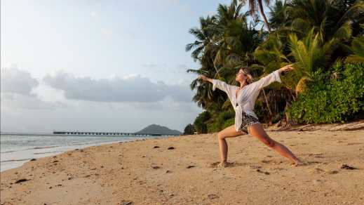 Eine Frau praktiziert Yoga am Strand