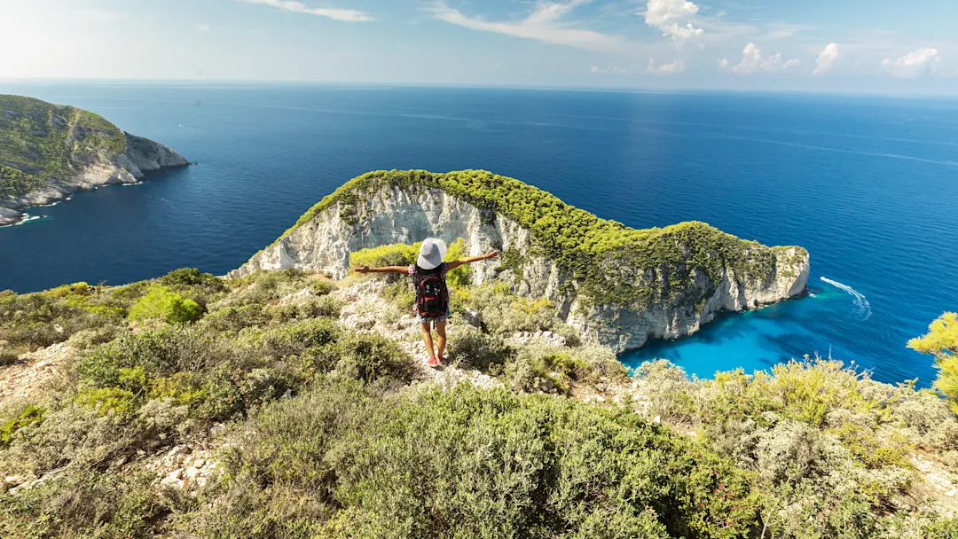 Wanderer mit Blick auf die Bucht von Navagio, umgeben von türkisblauem Wasser. Zakynthos, Ionische Inseln, Griechenland.