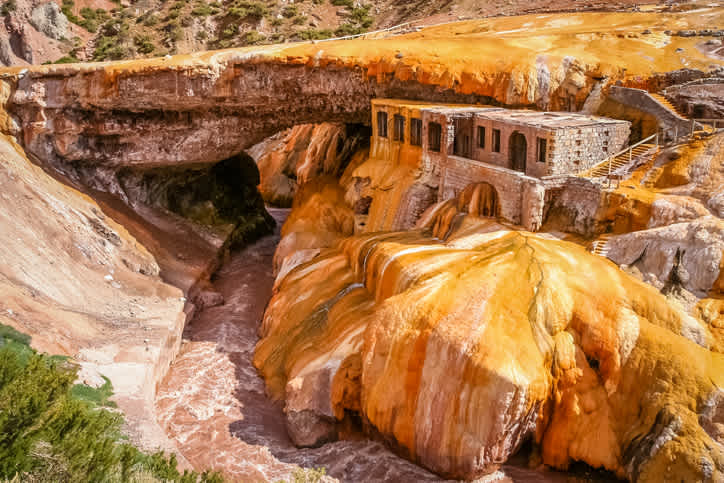 Entdecken Sie die Natursteinbrücke Puente del Inca über den Rio Mendoza während Ihrer Reise nach Mendoza.
