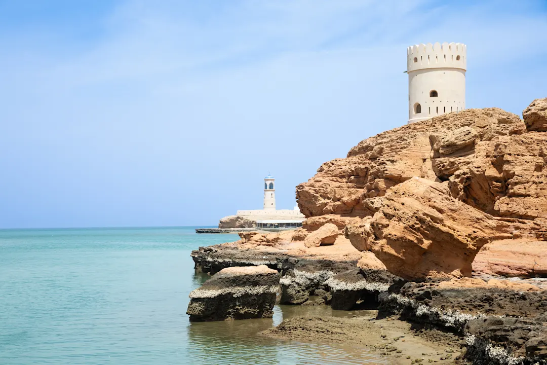 Arabischer Wachturm und Leuchtturm von Al Ayjah an einer felsigen Küste, Sur, Sultanat Oman.