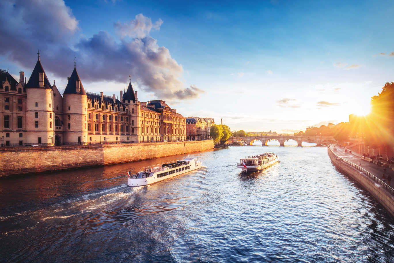 Europe, France, Paris, a view of the River Seine at sunset with boats cruising towards a bridge.