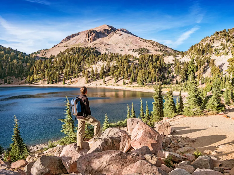 Westküste, USA Wanderer genießt die Aussicht auf einen See und Berge im Lassen Volcanic National Park, Kalifornien, USA.