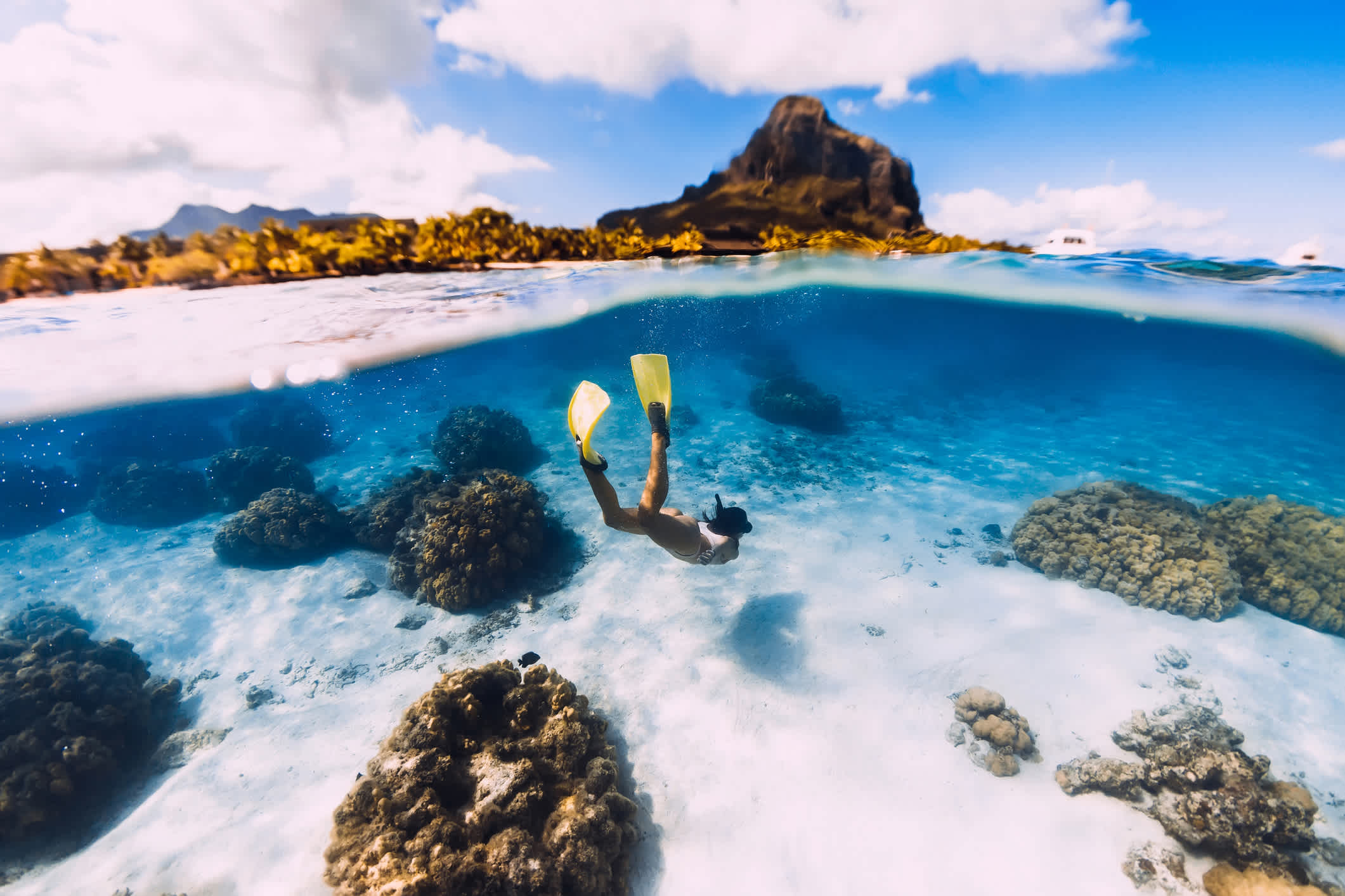Frau Freediver gleitet über sandiges Meer mit gelben Flossen in transparentem Ozean. Freitauchen in Mauritius