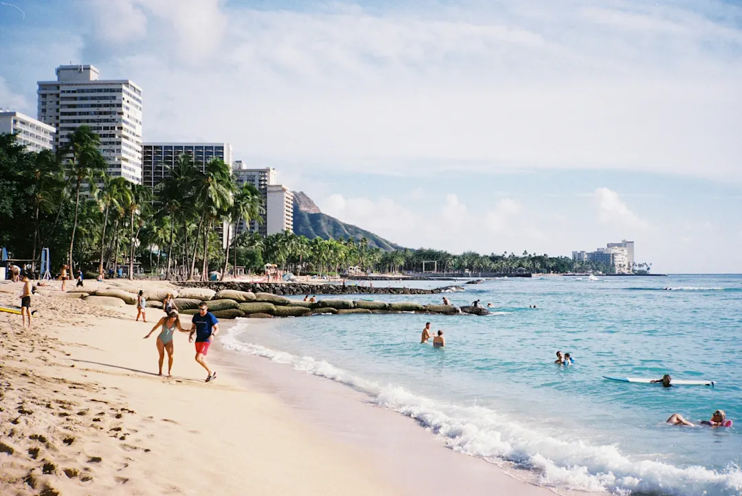 Strand in Honolulu mit Hochhäusern im Hintergrund und einigen Badegästen, Hawaii